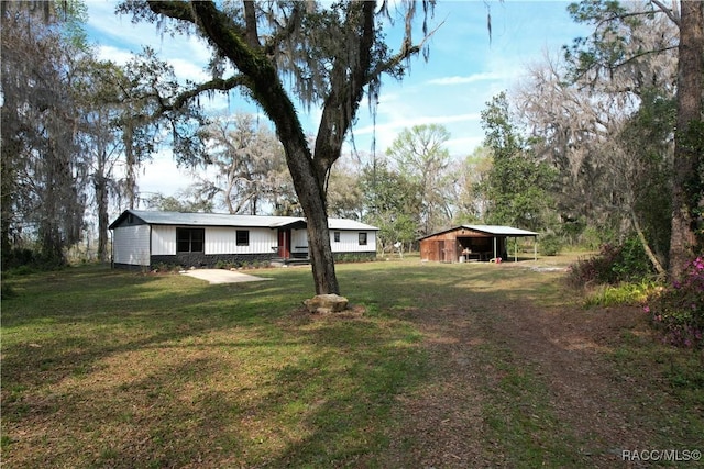 view of yard with a carport and an outbuilding