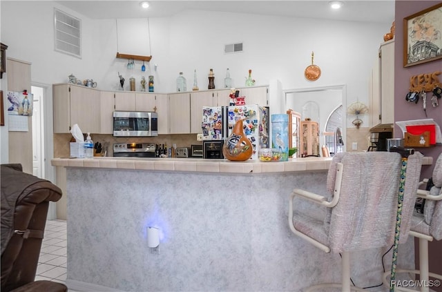 kitchen featuring tile countertops, visible vents, appliances with stainless steel finishes, and tasteful backsplash