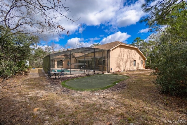 rear view of property with glass enclosure, an outdoor pool, a patio, and stucco siding