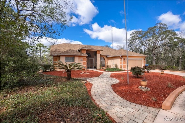 view of front of home featuring a garage, driveway, and stucco siding