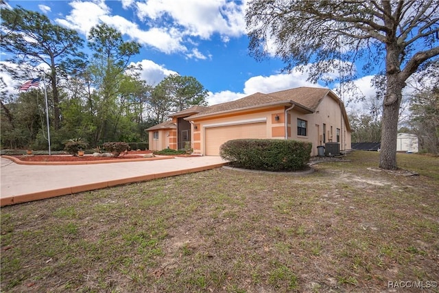 view of side of home featuring a garage, central AC, a yard, and stucco siding