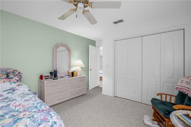 bedroom featuring ceiling fan, visible vents, a closet, and light colored carpet