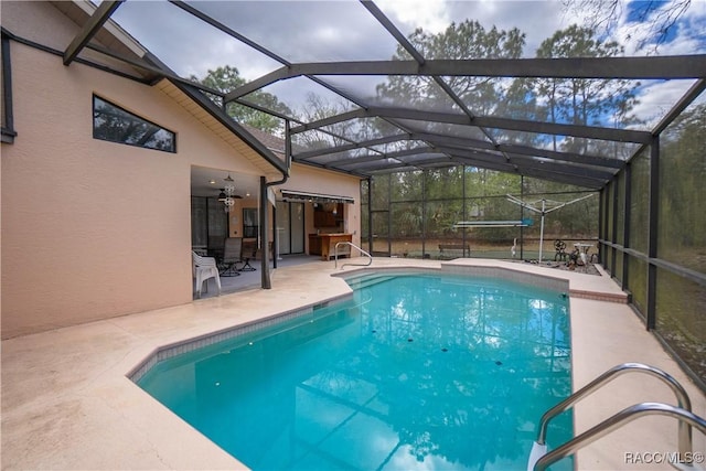 outdoor pool with glass enclosure and a patio