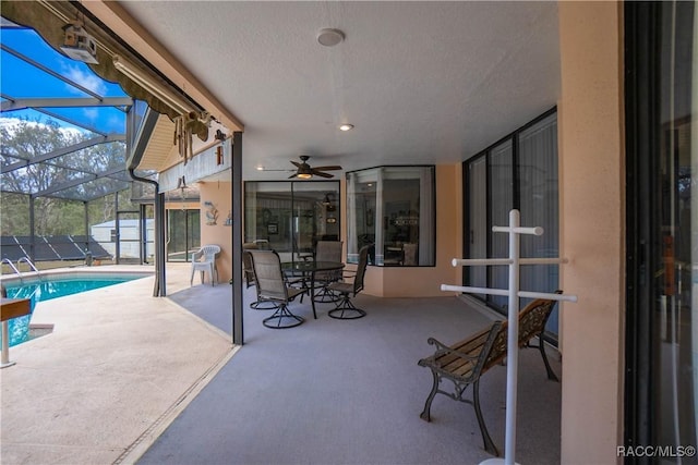 view of patio / terrace featuring a fenced in pool, glass enclosure, and ceiling fan