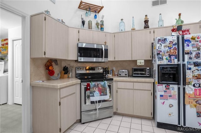 kitchen featuring a toaster, tile countertops, visible vents, backsplash, and appliances with stainless steel finishes