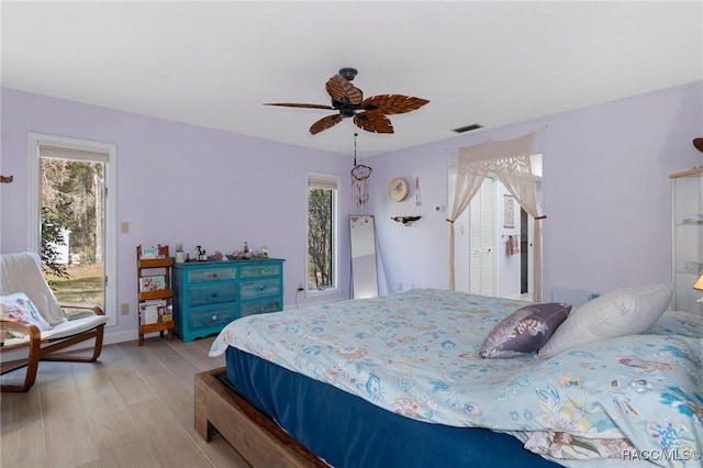 bedroom with multiple windows, ceiling fan, light hardwood / wood-style flooring, and access to outside