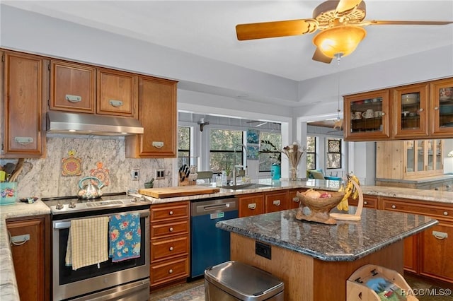 kitchen featuring sink, tasteful backsplash, dark stone countertops, a kitchen island, and stainless steel appliances