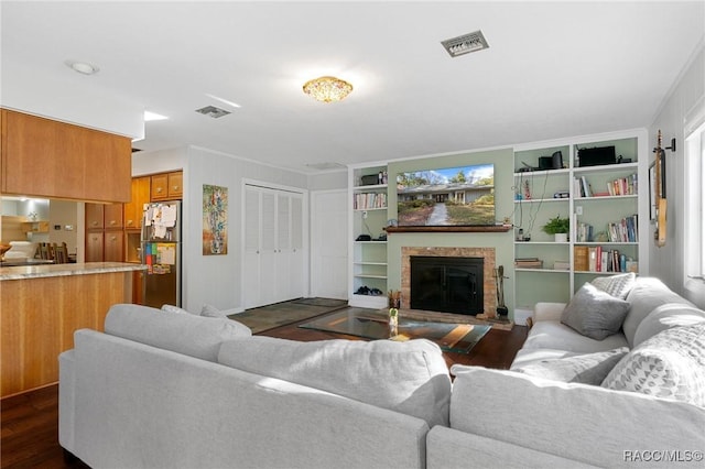 living room featuring built in shelves and dark wood-type flooring