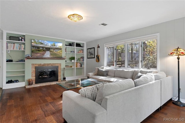 living room featuring dark hardwood / wood-style floors and built in shelves