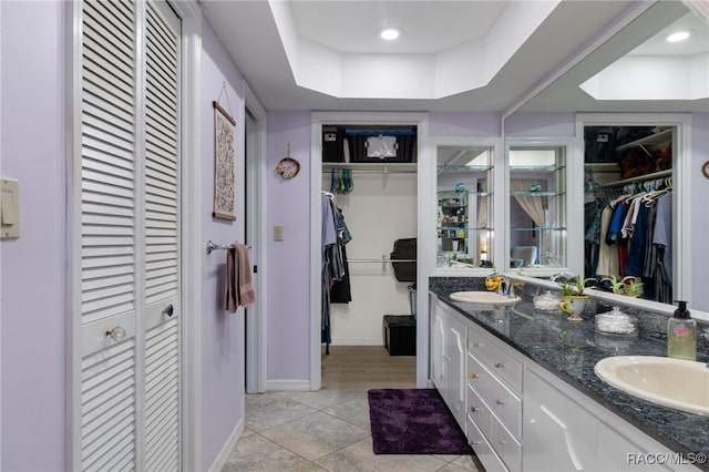 bathroom featuring vanity, tile patterned floors, and a tray ceiling