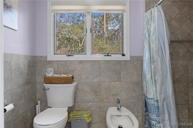 bathroom featuring a bidet, toilet, tile walls, and a shower with shower curtain