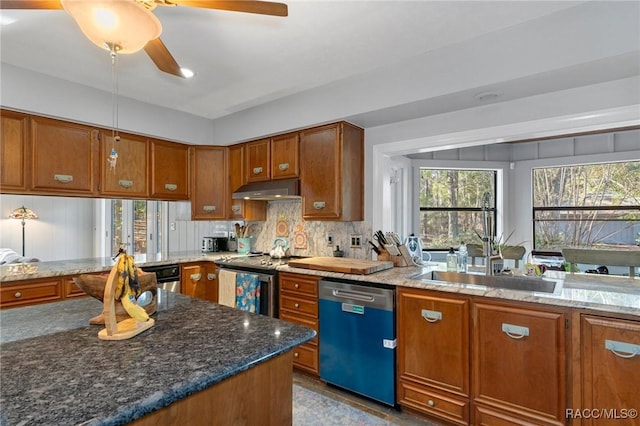 kitchen featuring tasteful backsplash, appliances with stainless steel finishes, sink, and dark stone countertops