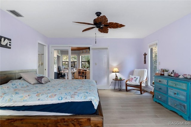 bedroom with multiple windows, ceiling fan, and light hardwood / wood-style flooring