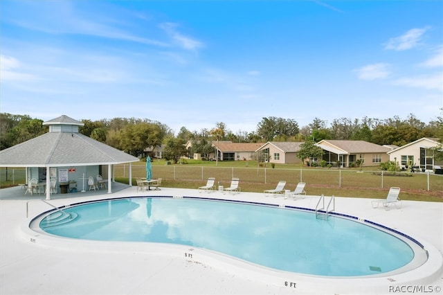 view of pool with a patio area and a lawn