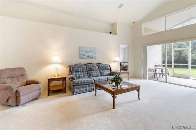 living room featuring a healthy amount of sunlight, carpet floors, and high vaulted ceiling