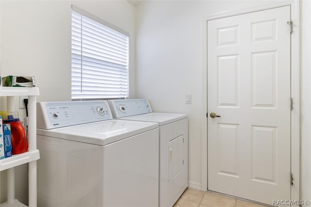 clothes washing area featuring washer and dryer and light tile patterned flooring