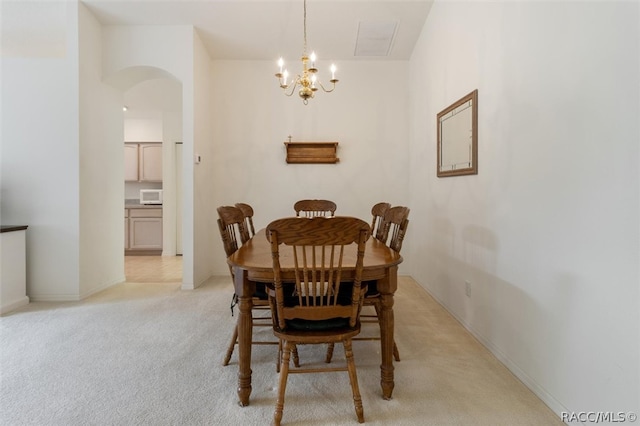 dining room with a chandelier and light colored carpet