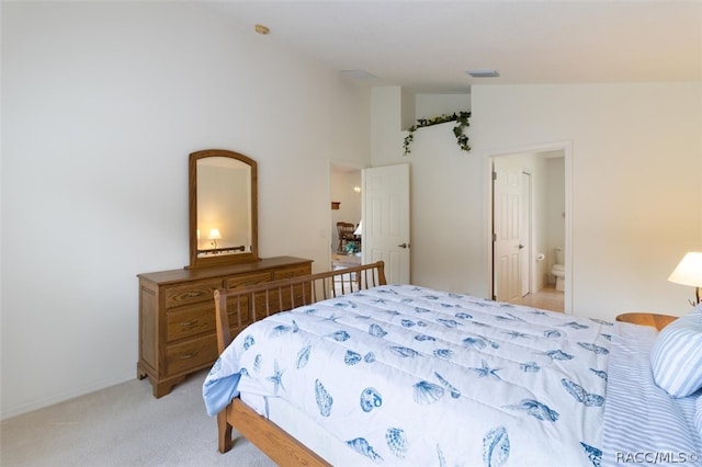 carpeted bedroom featuring connected bathroom and lofted ceiling