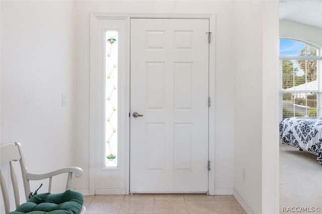 entrance foyer featuring light tile patterned flooring and vaulted ceiling