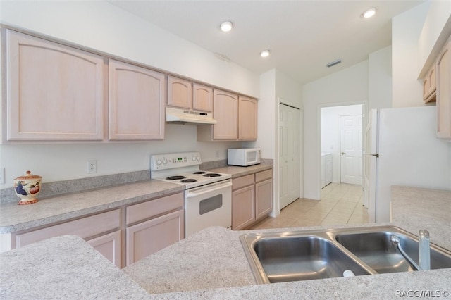 kitchen with light brown cabinetry, white appliances, vaulted ceiling, sink, and light tile patterned floors