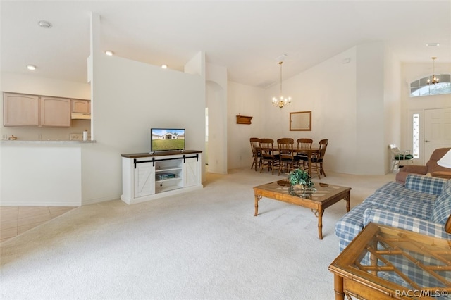 carpeted living room featuring high vaulted ceiling and a notable chandelier