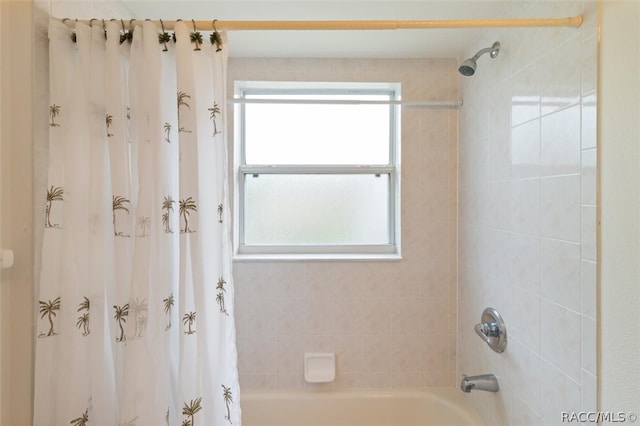 bathroom with a healthy amount of sunlight and shower / bath combo with shower curtain