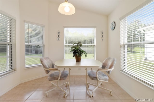 tiled dining space with lofted ceiling