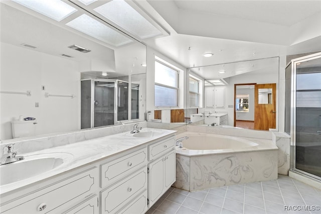 bathroom featuring tile patterned floors, vanity, shower with separate bathtub, and a skylight