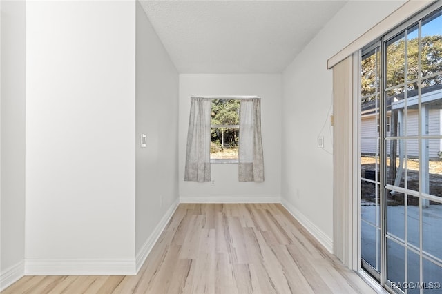 empty room featuring a textured ceiling and light hardwood / wood-style floors