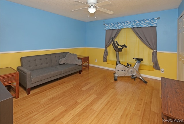 workout area with hardwood / wood-style flooring, ceiling fan, and a textured ceiling