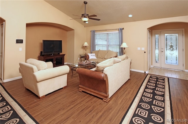 living room with hardwood / wood-style floors, a textured ceiling, vaulted ceiling, and ceiling fan