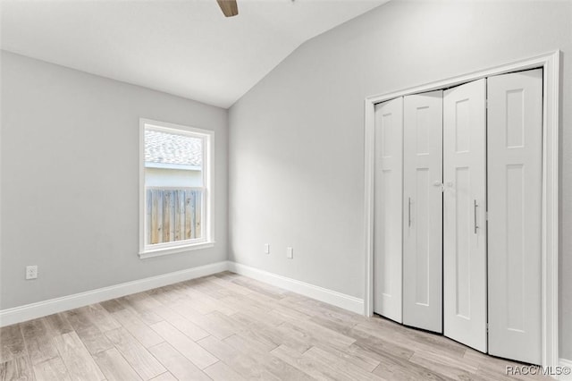 unfurnished bedroom with vaulted ceiling, a closet, ceiling fan, and light hardwood / wood-style floors