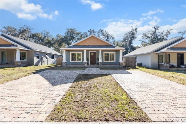 view of front of home with cooling unit, a front lawn, and a porch