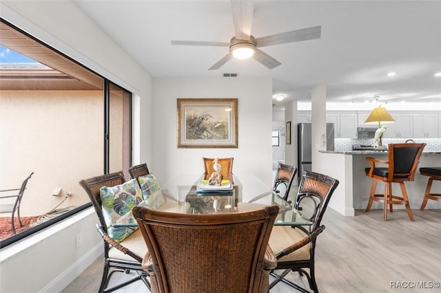 dining room with light hardwood / wood-style flooring and ceiling fan