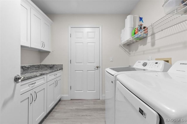 washroom featuring cabinets, washer and dryer, and light wood-type flooring