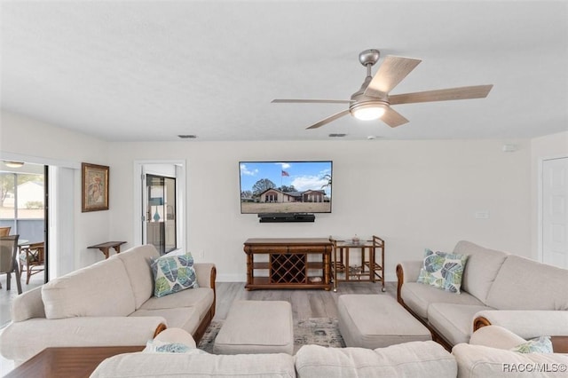 living room featuring light hardwood / wood-style flooring and ceiling fan