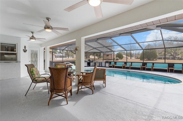 view of pool featuring a patio area, outdoor lounge area, and glass enclosure