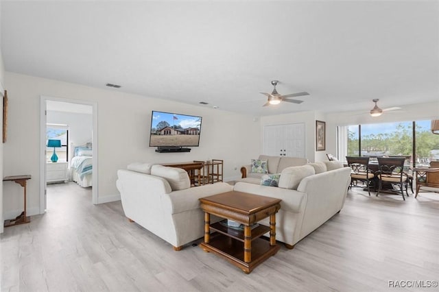 living room featuring ceiling fan and light hardwood / wood-style flooring