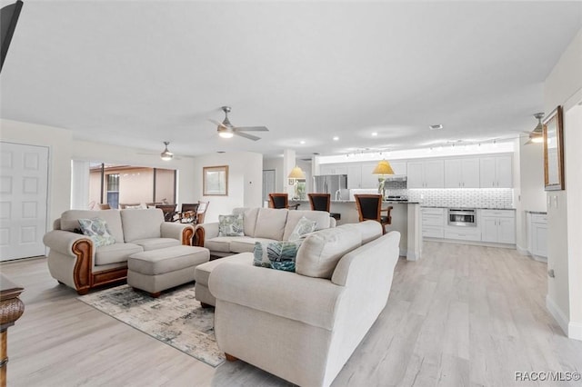 living room with ceiling fan and light hardwood / wood-style floors