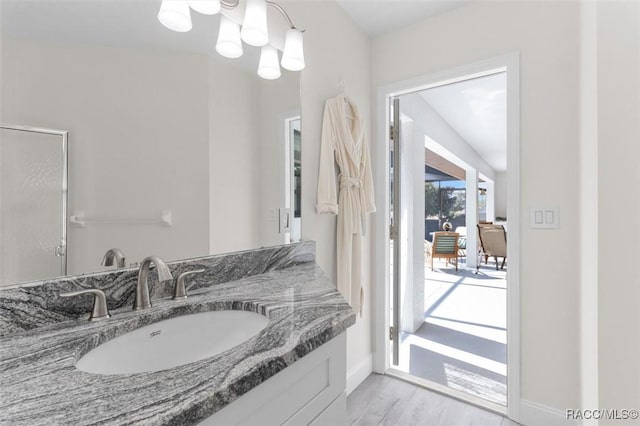 bathroom with hardwood / wood-style flooring, vanity, and a notable chandelier