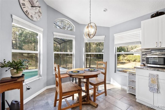 sunroom / solarium with vaulted ceiling, plenty of natural light, and a notable chandelier