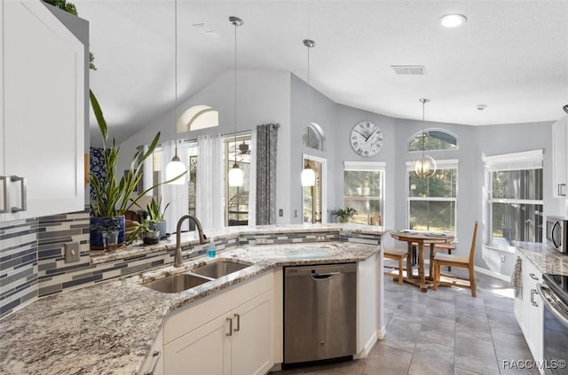 kitchen with sink, white cabinets, hanging light fixtures, light stone counters, and stainless steel appliances