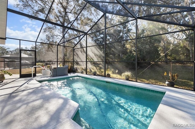 view of swimming pool featuring a lanai and a patio