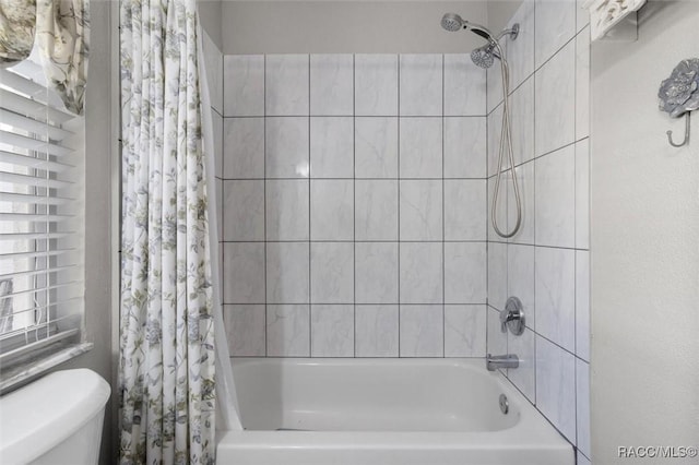 bathroom with shower / bath combination with curtain and toilet