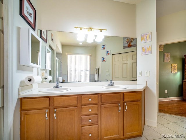 bathroom with a shower with door, tile patterned floors, and vanity