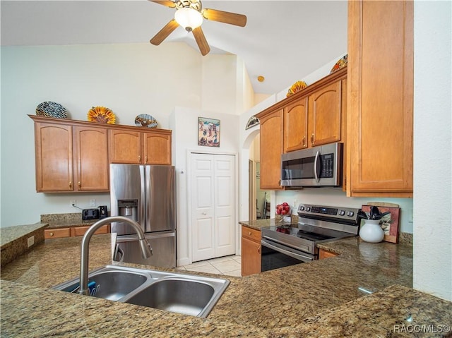 kitchen featuring lofted ceiling, ceiling fan, sink, stainless steel appliances, and light tile patterned floors