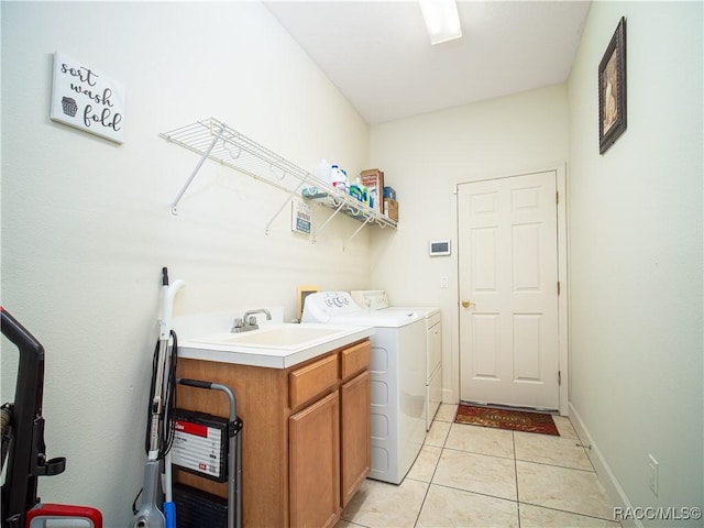 clothes washing area with sink, light tile patterned flooring, separate washer and dryer, and cabinets