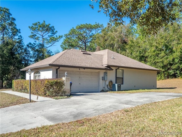 view of side of home featuring a lawn, central AC, and a garage