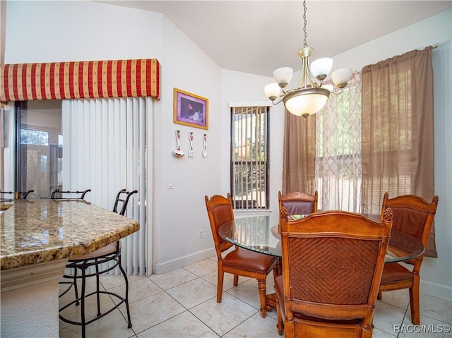 tiled dining room with a chandelier and vaulted ceiling