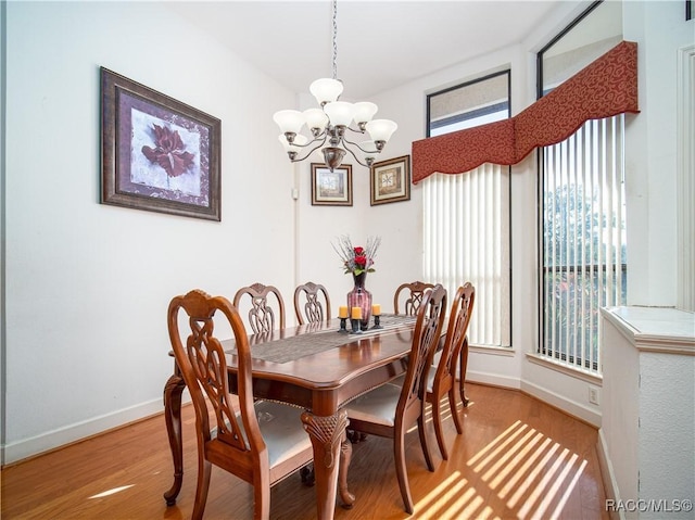 dining room featuring light wood-type flooring and a notable chandelier